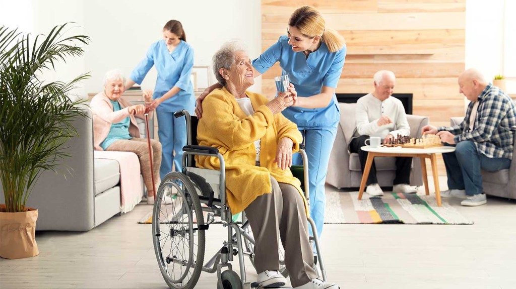 Caregivers and residents in a modern assisted living common area